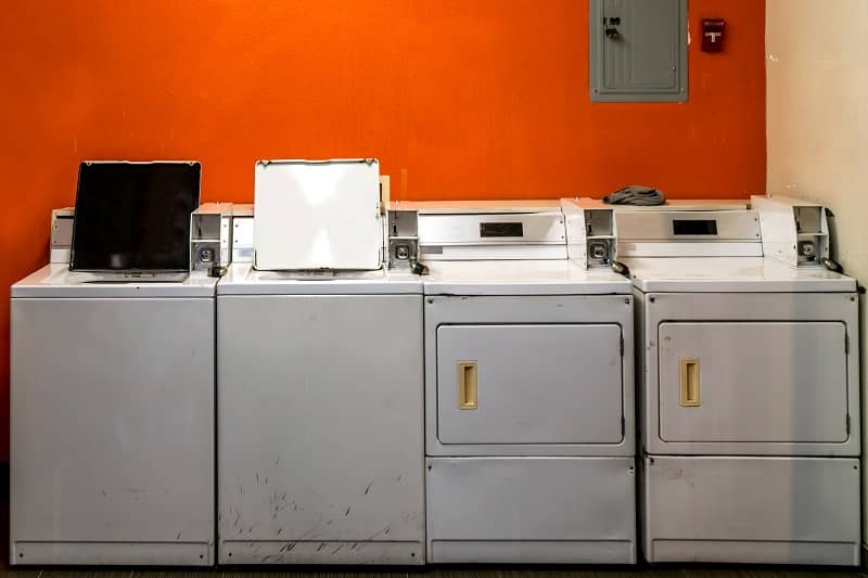 old coin laundry washing and drying machines with orange wall background cm